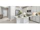 Modern kitchen with white cabinets, stainless steel appliances, and a spacious island at 2894 Butterfly Jasmine Trl, Sarasota, FL 34240