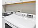 Laundry room featuring a new front load washer and dryer and white cabinets at 2894 Butterfly Jasmine Trl, Sarasota, FL 34240