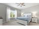 Cozy bedroom with white accents, a ceiling fan, a large window, and plush carpeting at 2894 Butterfly Jasmine Trl, Sarasota, FL 34240