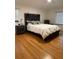 Bedroom with hardwood floors, nightstand, and large decorative headboard at 33 Tee View Pl, Rotonda West, FL 33947