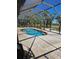 Screen-enclosed swimming pool with brick patio and lush landscaping at 33 Tee View Pl, Rotonda West, FL 33947