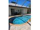 Inviting pool with brick trim surrounded by patio and lush landscape, next to the home's outdoor dining area at 33 Tee View Pl, Rotonda West, FL 33947