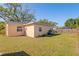 Well-maintained backyard with a lush green lawn and partial view of a fenced pool area at 3883 Tampico Dr, Sarasota, FL 34235