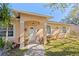 Inviting front porch with decorative columns, charming decor, and a well-maintained landscape at 3883 Tampico Dr, Sarasota, FL 34235