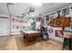 Open garage with a pool table and a motorcycle along with various decorative signs on the walls at 3883 Tampico Dr, Sarasota, FL 34235