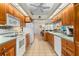 Spacious kitchen with wood cabinetry and tiled floors that opens up to the living area at 3883 Tampico Dr, Sarasota, FL 34235