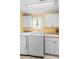 Bright laundry room featuring modern washer and dryer units, cabinets and a sink at 3883 Tampico Dr, Sarasota, FL 34235