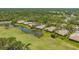 Aerial view of the community highlights homes bordering a serene pond and lush green golf course, perfect for nature enthusiasts at 3950 Oakley Greene # 36, Sarasota, FL 34235