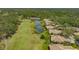 Aerial view showing a home backing onto a golf course and pond, framed by mature trees and pristine landscaping at 3950 Oakley Greene # 36, Sarasota, FL 34235
