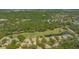 Aerial view reveals homes nestled amongst lush greenery, featuring tranquil ponds and a winding golf course at 3950 Oakley Greene # 36, Sarasota, FL 34235