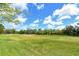Lush green backyard and landscape featuring mature trees and scenic golf course views at 3950 Oakley Greene # 36, Sarasota, FL 34235