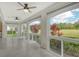 Bright Florida room featuring tiled flooring, ceiling fans, and large arched windows offering views of the lush green outdoor space at 3950 Oakley Greene # 36, Sarasota, FL 34235