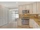 This eat-in kitchen features a stove with a built-in oven, white cabinets, and granite counters at 3950 Oakley Greene # 36, Sarasota, FL 34235