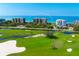 Aerial view of luxury condos overlooking a lush golf course and the ocean at 435 L Ambiance Dr # H902, Longboat Key, FL 34228