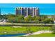 Luxury condo building overlooking lush landscaping, golf course, and the ocean at 435 L Ambiance Dr # H902, Longboat Key, FL 34228