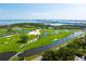 Beautiful aerial view of golf course community with water features, lush greenery, and city skyline at 435 L Ambiance Dr # H902, Longboat Key, FL 34228