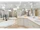 Bright bathroom with garden tub, marble counters, and gold fixtures at 435 L Ambiance Dr # H902, Longboat Key, FL 34228