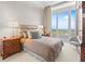 Bedroom with water view from large window and neutral toned walls at 435 L Ambiance Dr # H902, Longboat Key, FL 34228