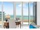 Bright den with ocean views from floor-to-ceiling windows and access to a private balcony at 435 L Ambiance Dr # H902, Longboat Key, FL 34228
