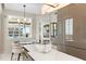 Open-concept dining area with stylish chandelier and adjacent modern kitchen at 435 L Ambiance Dr # H902, Longboat Key, FL 34228