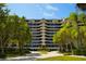 Modern exterior of the property with multiple balconies and mature trees at 435 L Ambiance Dr # H902, Longboat Key, FL 34228