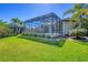 Expansive backyard features screened-in pool area, lush lawn, and mature landscaping at 435 La Sila Ct, Punta Gorda, FL 33950
