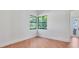 Bedroom with hardwood floors, a black trimmed corner window, and exterior door at 435 La Sila Ct, Punta Gorda, FL 33950
