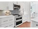 Modern kitchen features white cabinetry, subway tile backsplash and stainless steel appliances at 435 La Sila Ct, Punta Gorda, FL 33950