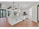 Bright, open kitchen features an island with a farmhouse sink, pendant lighting, and hardwood floors at 435 La Sila Ct, Punta Gorda, FL 33950