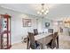Open dining room with chandelier, wood table, cabinet for china, and access to living spaces at 4420 Tecumseh Trl # 38, Sarasota, FL 34233