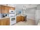 Well-equipped kitchen with wood cabinets, a smooth cooktop, and a convenient breakfast bar at 4420 Tecumseh Trl # 38, Sarasota, FL 34233