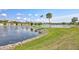 Scenic lake view with landscaped shoreline, flag, and community buildings, ideal for peaceful living at 4420 Tecumseh Trl # 38, Sarasota, FL 34233