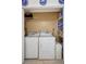 Bright laundry room featuring white appliances, storage shelves, and a decorative bench at 4420 Tecumseh Trl # 38, Sarasota, FL 34233