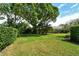 A well-maintained lush green lawn with mature trees and landscaped borders providing a serene outdoor space at 4444 Highland Oaks Cir, Sarasota, FL 34235
