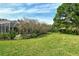 Lush green backyard with mature trees, tropical plants, and a view of the screened-in lanai at 4444 Highland Oaks Cir, Sarasota, FL 34235