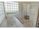Bathroom featuring soaking tub next to glass enclosed shower and glass block window at 4444 Highland Oaks Cir, Sarasota, FL 34235