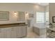 Bright bathroom with a tub and shower with glass block window for privacy at 4444 Highland Oaks Cir, Sarasota, FL 34235