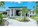 Elegant clubhouse entrance featuring a covered porch, lush landscaping, and a welcoming pathway at 4444 Highland Oaks Cir, Sarasota, FL 34235