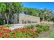 Welcoming entrance sign for The Meadows community, surrounded by lush landscaping and vibrant red flowers at 4444 Highland Oaks Cir, Sarasota, FL 34235