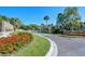 The attractive community entrance is adorned with colorful flowers and manicured landscaping, inviting guests and residents alike at 4444 Highland Oaks Cir, Sarasota, FL 34235