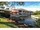 Exterior view of a waterfront building with a covered patio, a red awning and lots of windows on the second story at 4444 Highland Oaks Cir, Sarasota, FL 34235