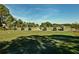 Golf carts on the pristine green course with blue skies offer a relaxing recreational experience for residents at 4444 Highland Oaks Cir, Sarasota, FL 34235