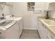 Laundry room with front load washer and dryer and plenty of storage at 4444 Highland Oaks Cir, Sarasota, FL 34235