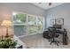 Bright office space with large windows offering views of the landscaped yard, tile flooring, and a dedicated workspace at 4444 Highland Oaks Cir, Sarasota, FL 34235