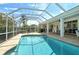 Enjoy the Florida sunshine in this screened-in pool area with outdoor seating and lush landscaping at 4444 Highland Oaks Cir, Sarasota, FL 34235