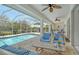 Spacious screened patio with comfortable seating, ceiling fans, and a view of the beautiful pool area at 4444 Highland Oaks Cir, Sarasota, FL 34235