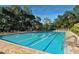 Long swimming pool with divided lanes, lounge chairs, and landscaping at 4444 Highland Oaks Cir, Sarasota, FL 34235