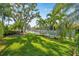 A beautifully landscaped backyard with lush green lawn, mature trees and water view at 4527 Barracuda Dr, Bradenton, FL 34208