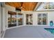 Covered patio featuring a wood ceiling, ceiling fan, and glass doors to the pool area at 4527 Barracuda Dr, Bradenton, FL 34208