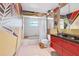 Funky bathroom with unique geometric painted walls, bath tub, and red vanity at 480 58Th St, Sarasota, FL 34243